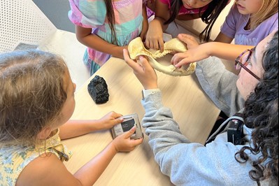 Children surrounding a fossil