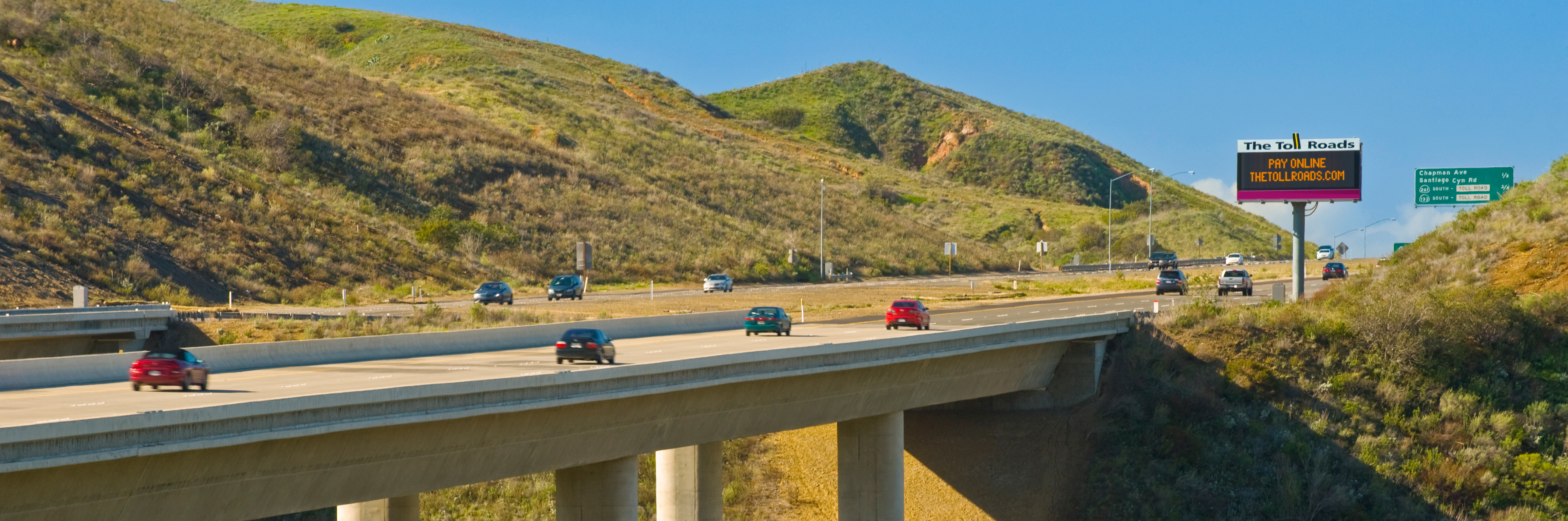 Vehicles driving over a bridge on The Toll Roads